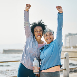 Two older women celebrating with arms in the air